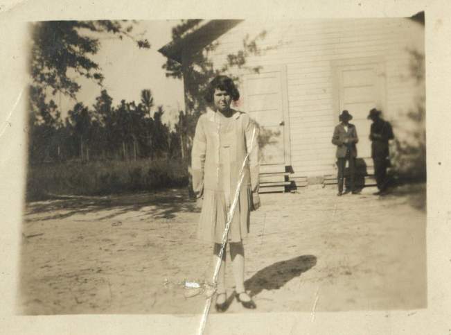 Old photo of a lady with two men in hats in the background